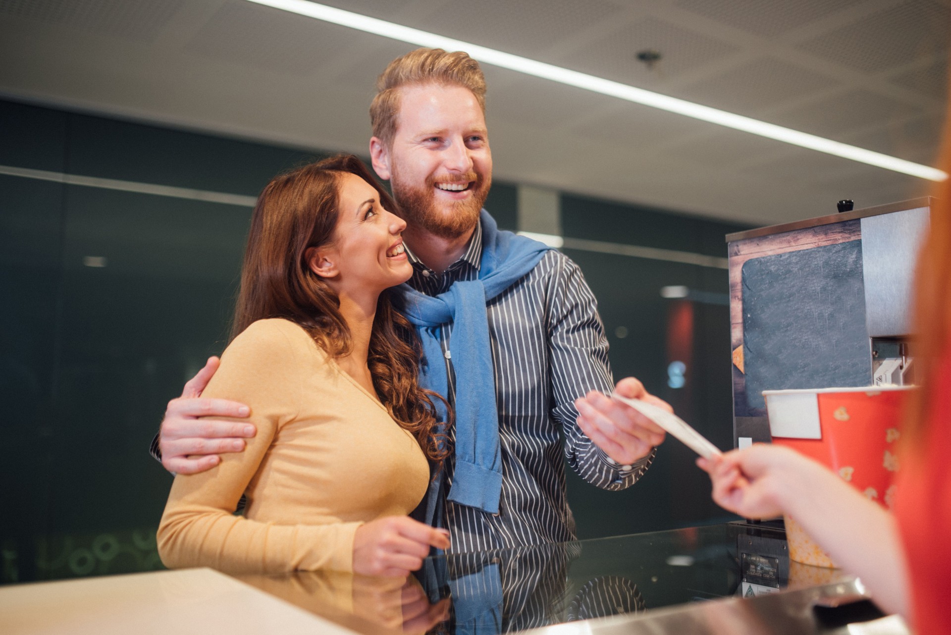 Man and woman buying movie tickets